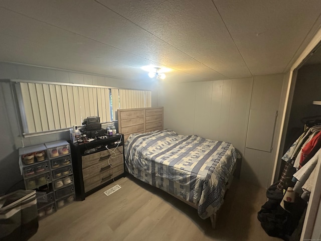 bedroom with light hardwood / wood-style floors and a textured ceiling