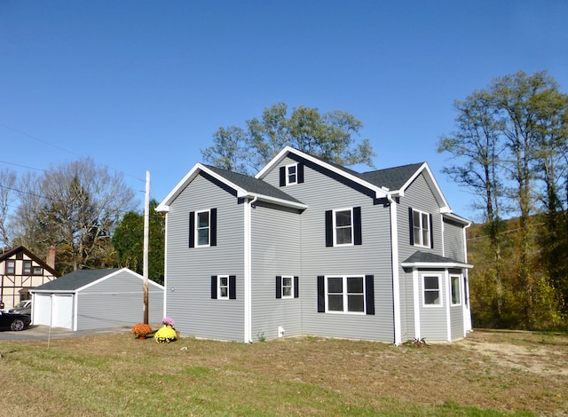 view of property exterior featuring a garage, an outbuilding, and a yard