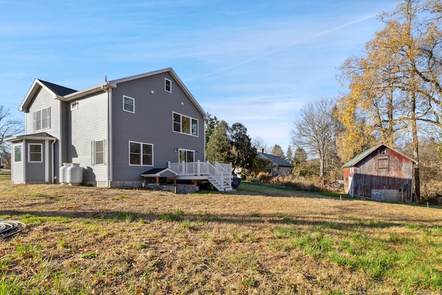 exterior space featuring a wooden deck, a yard, and an outdoor structure