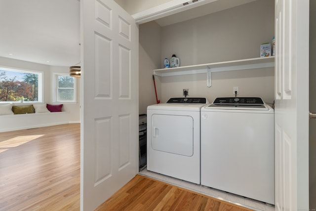 laundry area featuring independent washer and dryer and light hardwood / wood-style flooring