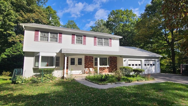 view of front of property featuring a garage, a front yard, and covered porch