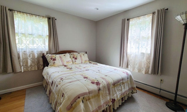 bedroom with light hardwood / wood-style flooring and a baseboard radiator