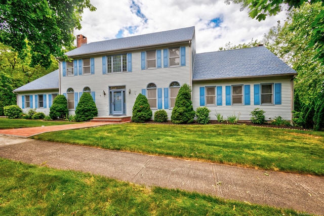 colonial home featuring a front lawn