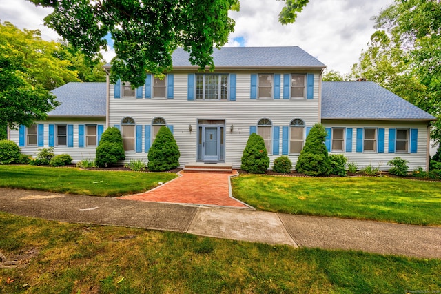 colonial house featuring a front lawn