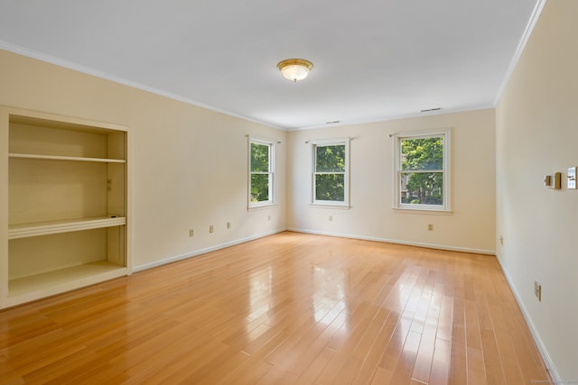 interior space with crown molding, built in features, and light wood-type flooring