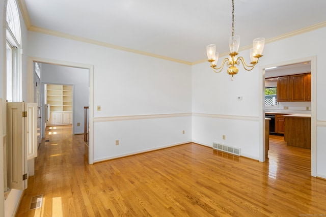 interior space with an inviting chandelier, crown molding, and light wood-type flooring