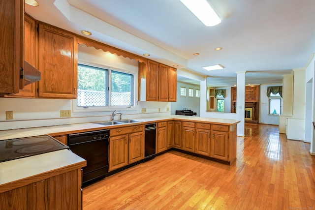 kitchen featuring sink, dishwasher, kitchen peninsula, and light wood-type flooring