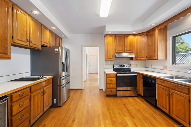 kitchen with sink, appliances with stainless steel finishes, light hardwood / wood-style flooring, and beverage cooler