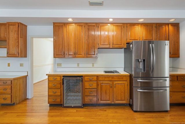 kitchen featuring light hardwood / wood-style floors, beverage cooler, and stainless steel fridge with ice dispenser