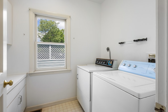 washroom featuring independent washer and dryer and cabinets