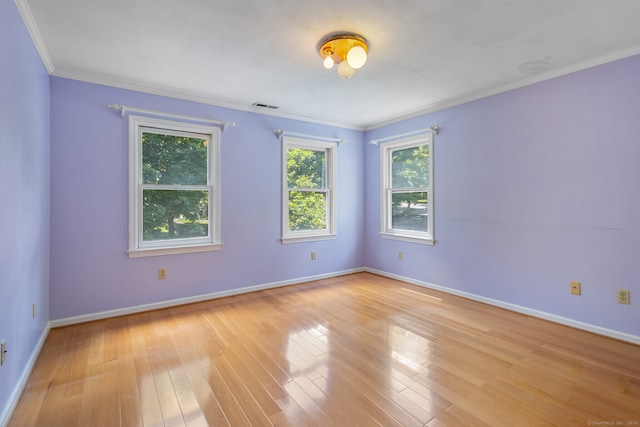 spare room featuring ornamental molding and light hardwood / wood-style flooring