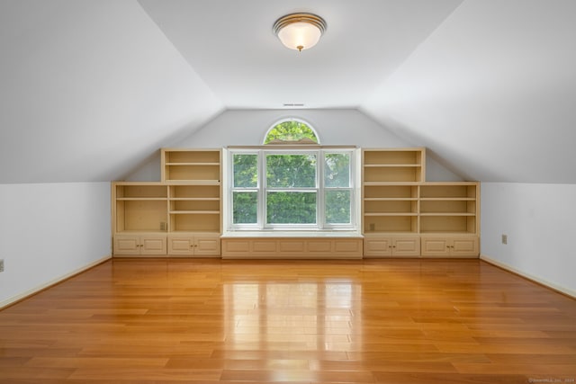 bonus room featuring lofted ceiling and light hardwood / wood-style flooring