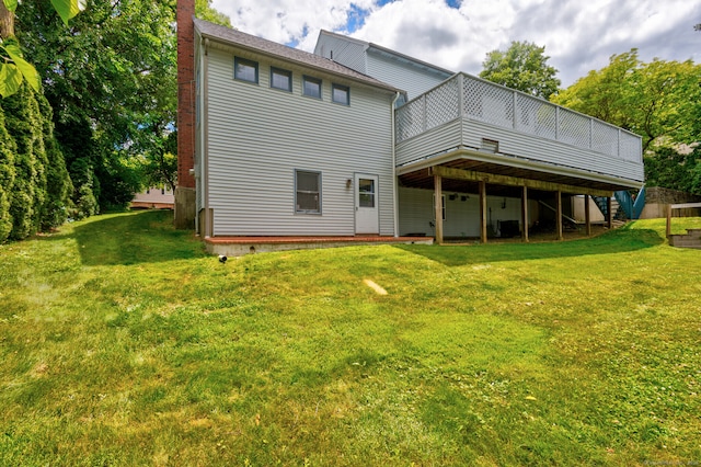 back of property featuring a wooden deck and a yard