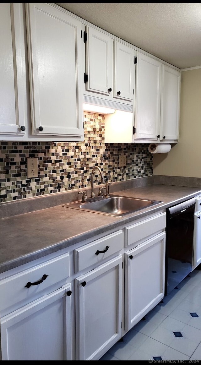 kitchen featuring dishwasher, sink, light tile patterned flooring, white cabinets, and tasteful backsplash