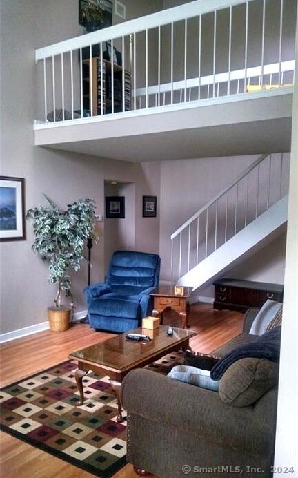 living room featuring a towering ceiling and wood-type flooring