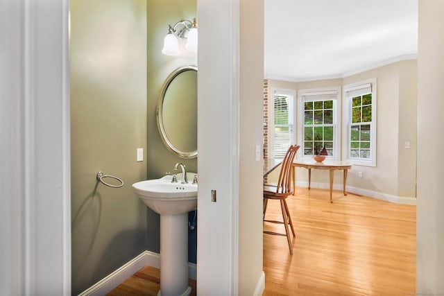 bathroom featuring ornamental molding and hardwood / wood-style flooring