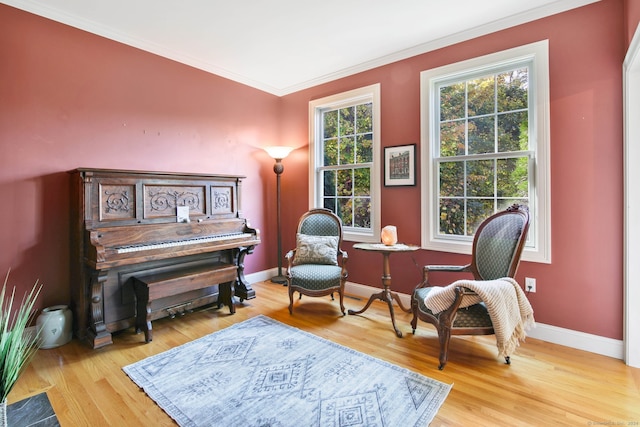 living area with light hardwood / wood-style floors and crown molding