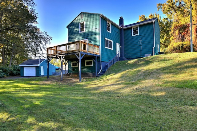 rear view of house featuring a yard, an outdoor structure, and a wooden deck