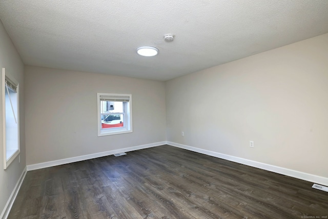 unfurnished room with dark hardwood / wood-style floors and a textured ceiling