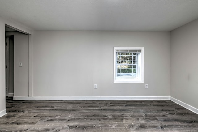 unfurnished room featuring a textured ceiling and dark hardwood / wood-style flooring