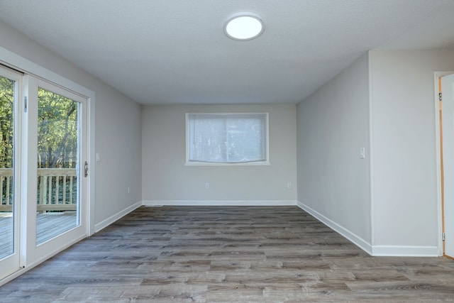 spare room with light hardwood / wood-style flooring and a textured ceiling