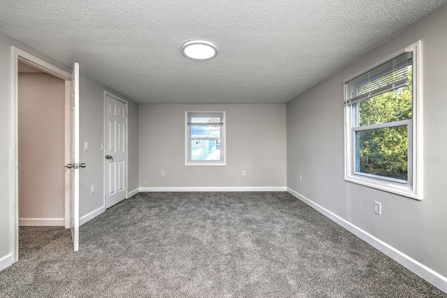 empty room with carpet and a textured ceiling