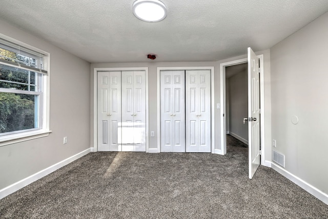 unfurnished bedroom with a textured ceiling and multiple windows