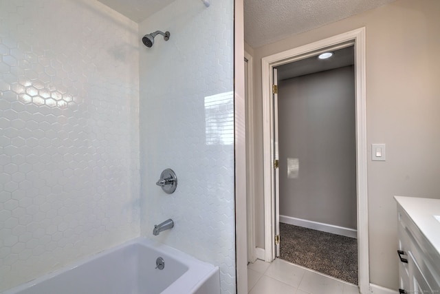 bathroom with vanity, tiled shower / bath combo, a textured ceiling, and tile patterned flooring