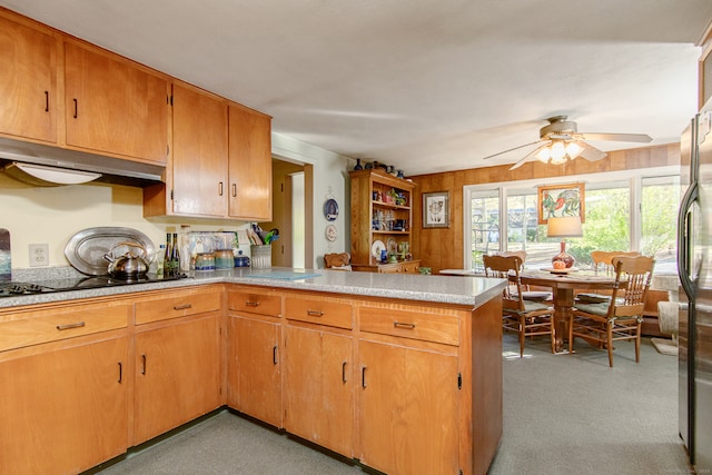 kitchen with black electric stovetop, extractor fan, kitchen peninsula, light colored carpet, and ceiling fan