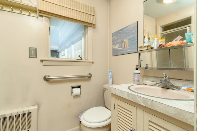 bathroom with toilet, vanity, and radiator