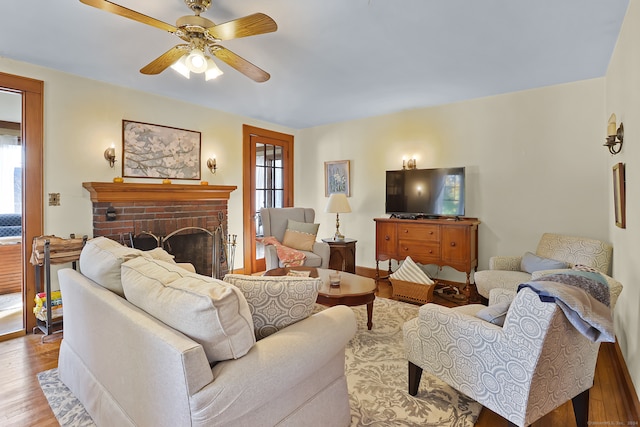 living room featuring a fireplace, light hardwood / wood-style floors, and ceiling fan