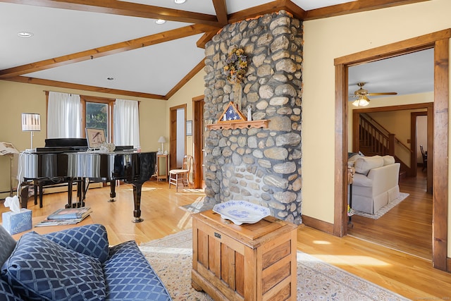 living room featuring ceiling fan, light hardwood / wood-style flooring, and vaulted ceiling with beams