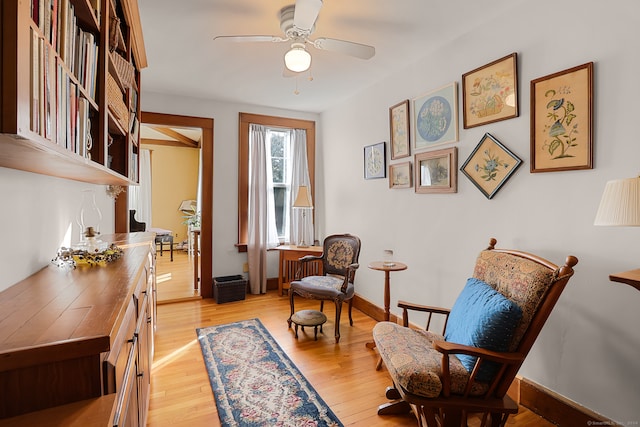 living area with ceiling fan and light hardwood / wood-style flooring