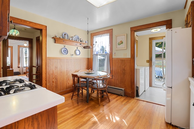 dining room with light hardwood / wood-style floors, a wealth of natural light, and separate washer and dryer