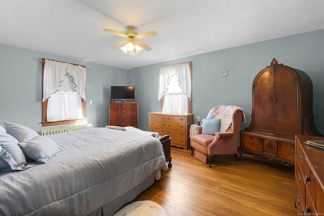 bedroom with light hardwood / wood-style floors and ceiling fan