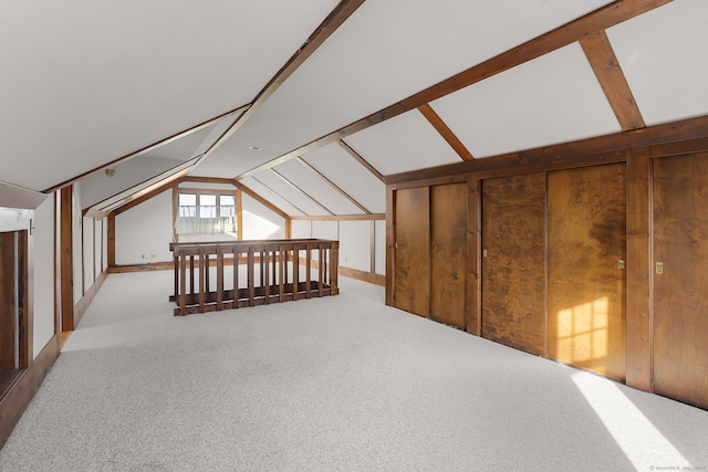 bonus room featuring light carpet and vaulted ceiling