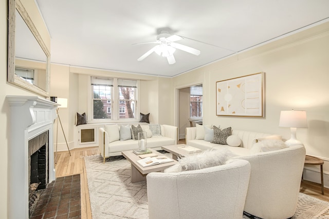 living room featuring hardwood / wood-style flooring, crown molding, and ceiling fan