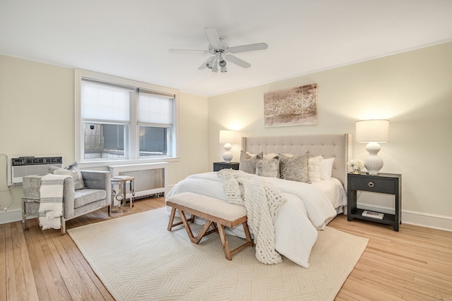 bedroom with ceiling fan, crown molding, light hardwood / wood-style floors, and a wall mounted AC