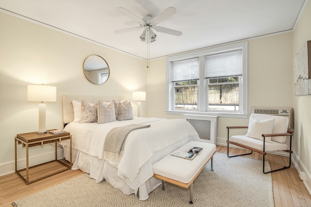 bedroom with ceiling fan, radiator, and light wood-type flooring