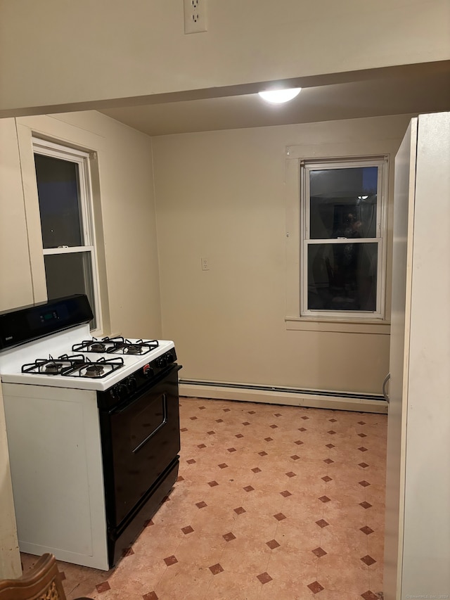 kitchen with white cabinets, white gas range, and a baseboard radiator