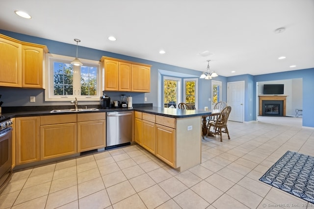 kitchen featuring plenty of natural light, sink, stainless steel appliances, and decorative light fixtures