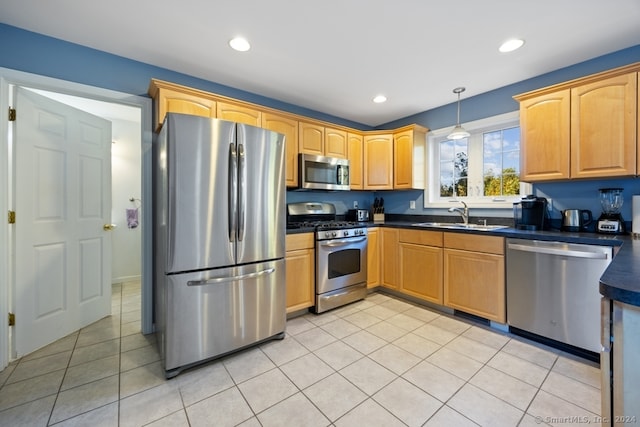 kitchen featuring hanging light fixtures, sink, light tile patterned floors, and stainless steel appliances