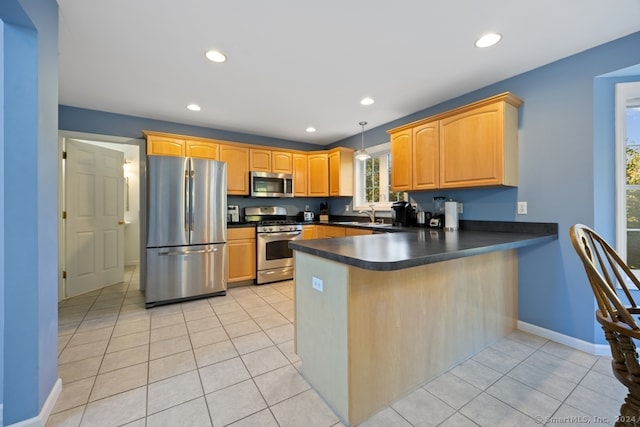 kitchen featuring kitchen peninsula, pendant lighting, stainless steel appliances, and light tile patterned floors