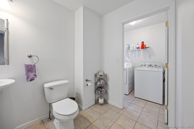 bathroom with washing machine and clothes dryer, tile patterned flooring, and toilet