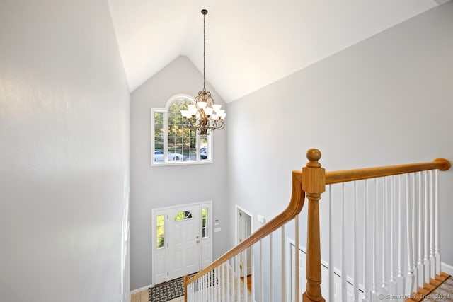 foyer featuring a notable chandelier and high vaulted ceiling