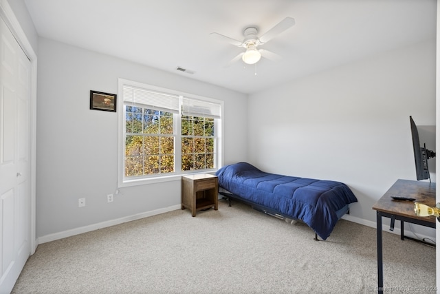 carpeted bedroom with ceiling fan and a closet