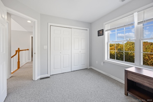 unfurnished bedroom featuring a closet and light colored carpet