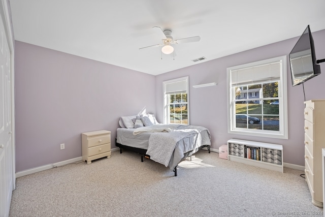 carpeted bedroom featuring ceiling fan and a closet