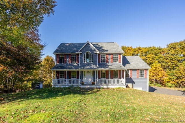 colonial inspired home with a porch and a front yard