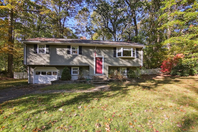 raised ranch featuring a front lawn and a garage